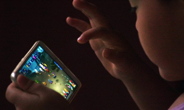 Trung Quốc giới hạn giờ chơi game với trẻ Một em bé đang chơi game online trên thiết bị di động - Ảnh: VCG/VCG