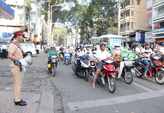 TP. HCM thí điểm dùng loa tuyên truyền an toàn giao thông Nữ cảnh sát giao thông phát loa tuyên truyền tại giao lộ. Ảnh: Cổng thông tin điện tử của Bộ Giao thông Vận tải.