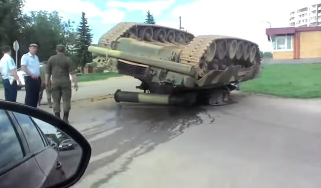 Video xe tăng T-80U của Nga lật ngửa vì.... rơi từ xe tải xuống đường Xe tăng T-80U lật ngửa sau khi rơi từ xe tải xuống đường - Ảnh từ clip