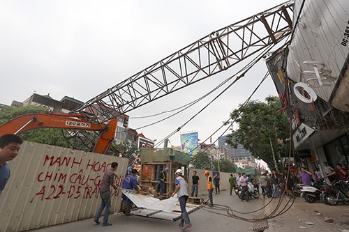 Dừng thi công, tổng kiểm tra dự án metro Nhổn - Ga Hà Nội Chiếc cần cẩu đổ vào hai căn nhà trên phố Cầu Giấy. Ảnh: Bá Đô