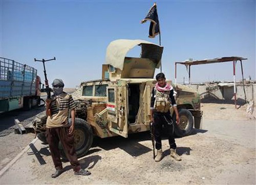 IS chiếm 2.300 xe bọc thép của Iraq Phiến quân IS đứng cạnh một xe Humvee chiếm được của Iraq tháng 6/2014. Ảnh: AP