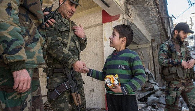 Không quân Nga yểm trợ quân đội Syria tấn công Trại tị nạnHandarat (video) Một sĩ quan cao cấp quân đội Syria nói chuyện với em bé trong khu vực vừa giải phóng ở Aleppo