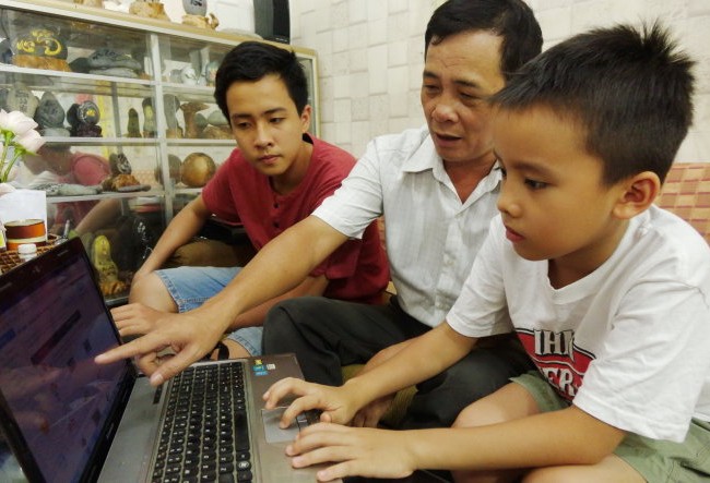 Cha làm phần mềm học chữ tặng con Tám năm trôi qua, con trai lớn của thầy Ninh giờ đã học lớp 9 (bìa trái). Phần mềm học chữ, tính toán giờ đây được thầy Ninh hướng dẫn tiếp cho con trai đang học tiểu học của mình - Ảnh: NHƯ HÙNG