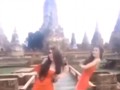 Hai phụ nữ mặc váy cam ngắn cũn nhảy nhót trước đền thiêng