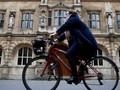 Một người phụ nữ đi xe đạp bên cạnh trường Oriel College ở Oxford, Anh (ảnh: Thomson Reuters)