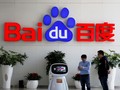 Khách giao dịch tương tác với robot AI của Baidu gần logo công ty tại trụ sở ở Bắc Kinh, Trung Quốc ngày 23/4/2021. Reuters