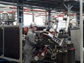 Công nhân Công ty VPIC thực hiện ráp phần khung sườn chiếc xe máy Ducati lên khuôn, các việc còn lại sẽ do robot thực hiện. Mỗi công nhân sẽ phụ trách 2 robot. Ảnh: Hà Thế An.