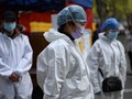 Tình nguyện viên Trung Quốc mặc niệm nạn nhân Covid-19 hôm 4/4 (Ảnh: AFP)