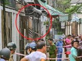 Lực lượng Công an đang phong toả hiện trường căn nhà (khoanh đỏ) bị cháy để điều tra