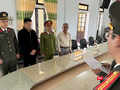 Công an TP Huế tống đạt quyết định khởi tố Hoàng Trung Nghĩa (thứ 2 từ trái sang). Ảnh: Công an cung cấp.