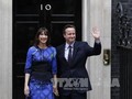 Thủ tướng Anh David Cameron (phải) và phu nhân Samantha bên ngoài Tòa nhà Số 10 phố Downing ở London ngày 8/5. Ảnh: AFP/ TTXVN