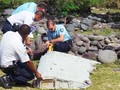 Các chuyên gia tiến hành kiểm tra mảnh vỡ nghi là của máy bay MH370 dạt vào bờ biển đảo Reunion, Pháp. Ảnh: Reuters