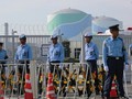Cảnh sát đứng canh gác ngoài khu Tổ hợp hạt nhân Sendai, ngăn chặn người biểu tình phản đối tái khởi động chương trình.