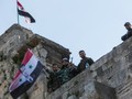 Cờ Syria được các binh sĩ gương cao trên tòa nhà mới chiếm lại