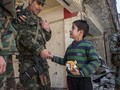Một sĩ quan cao cấp quân đội Syria nói chuyện với em bé trong khu vực vừa giải phóng ở Aleppo
