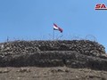 Quân đội Syria thượng cờ trên cao điểm Tal Al-Harrah thuộc vùng nông thôn Daraa. Ảnh video