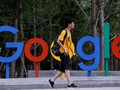 Một thanh niên đi qua khu vực đặt logo Google bên ngoài văn phòng của họ tại thủ đô Bắc Kinh, Trung Quốc - Ảnh: REUTERS