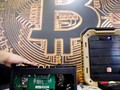 Thiết bị khai thác bitcoin trước logo đồng mã hóa, ảnh chụp ở Đài Loan hồi tháng 6. ẢNH: REUTERS