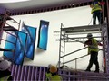 Các công nhân đang thi công poster quảng cáo điện thoại Huawei Mate X (ảnh: Phone Arena)