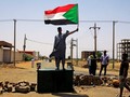 Một người biểu tình Sudan đứng trên hàng rào chắn ở Khartoum hôm thứ Tư (ảnh Reuters)