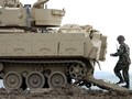 Một người lính đang đi bộ phía sau chiếc xe Bradley Fighting Vehicle trong cuộc diễn tập tại Fort Riley, Kansas (Ảnh Getty Images)