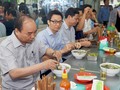 Thủ tướng và đoàn kiểm tra dừng chân, dùng điểm tâm tại một quán ăn đường phố thuộc phường Tân Thành, TPHCM. Ảnh: VGP/Quang Hiếu. 
