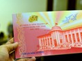 Một mẫu tiền lưu niệm được phát hành trong dịp kỷ niệm 65 thành lập ngành ngân hàng Việt Nam - Ảnh: LĐTĐ.