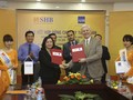 Bà Ngô Thu Hà (trái) – Phó Tổng Giám đốc SHB và ông Eric Sidgwick – Giám đốc quốc gia đại diện thường trú ADB tại Việt Nam thực hiện nghi lễ ký kết. (Ảnh: SHB)