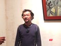 Họa sĩ Huỳnh Lê Nhật Tấn trả lời phỏng vấn tại triển lãm "Vết căn nguyên". Ảnh: Hòa Bình
