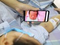Chị Vang ngắn nhìn đứa con thơ trong lúc điều trị ung thư máu.