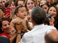 Em bé lập tức nín khóc sau khi được ông Obama bế. Ảnh: Reuters