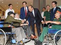 Thủ tướng thăm hỏi các đồng chí thương binh nặng tới dự buổi gặp mặt.