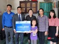 Em Lê Thị Trà My và gia đình nhận phần quà hỗ trợ dành cho trẻ em khuyết tật tiêu biểu. (Ảnh Hương Sen).