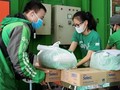 Bà Nguyễn Thái Hải Vân - Giám đốc Điều hành, Grab Việt Nam - tặng gạo và mì cho đối tác tài xế. Ảnh: Grab cung cấp.