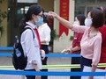 Cán bộ Trường THPT Phan Đình Giót (Hà Nội) đo thân nhiệt cho học sinh. Ảnh: Minh Nhân.