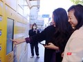 Người dân Hà Nội trải nghiệm trạm giao nhận thông minh bằng thao tác trên điện thoại và màn hình cảm ứng tại trạm.
