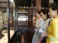 Du khách sử dụng smartphone với chip NFC gắn trên cổ vật trưng tại Cung đình Huế.