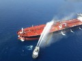 Một tàu của Iran cố gắng dập lửa cho con tàu bị tấn công trên vịnh Oman (Ảnh: Reuters)