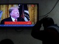 Một người Palestine theo dõi ông Trump tuyên bố kế hoạch hòa bình Trung Đông qua truyền hình (Ảnh: Reuters)