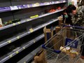 Người tiêu dùng mang khẩu trang đi lung sục các kệ hàng bán mỳ gói để tích trữ (Ảnh: Reuters)