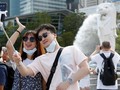 Du khách chụp ảnh tại công viên Merlion, Singapore (Ảnh: SCMP)