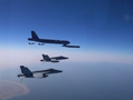 Máy bay ném bom B-52 Stratofortress của Mỹ được hộ tống bởi các chiến đấu cơ (Ảnh: RT)
