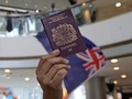 Một người Hong Kong cầm hộ chiếu BNO trên tay (Ảnh: Getty)