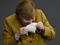 Bà Merkel nhịn cười khi đang đeo lại khẩu trang của mình (Ảnh: Getty)