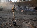 Một binh sĩ Ukraine kiểm tra hiện trường một vụ tấn công của Nga tại Kiev trong sáng 26/2 (Ảnh: AFP)