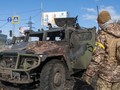 Một binh sĩ Nga kiểm tra xe quân sự bị hư hại ở Kharkiv, Ukraine ngày 27/2 (Ảnh: AP)