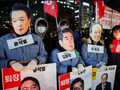 Người biểu tình đeo mặt nạ có hình Tổng thống Hàn Quốc Yoon Suk Yeol, cựu Bộ trưởng Quốc phòng Kim Yong-hyun và Choo Kyung-ho khi tập trung trước Quốc hội để yêu cầu luận tội ông Yoon. Ảnh: Reuters.