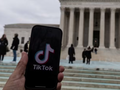 Logo TikTok được hiển thị trên điện thoại di động bên cạnh Tòa án Tối cao Mỹ, trong bức hình được chụp vào ngày 17/1. Ảnh: Reuters.