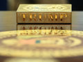 Một chiếc đế lót ly bằng vàng có dòng chữ “TRUMP” nằm trên một chiếc bàn trong Phòng Bầu dục của Nhà Trắng ở Washington. Ảnh: AFP.