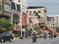Người dân đi xe máy qua một tòa nhà bị đổ sập sau trận động đất ở Mandalay, Myanmar hôm 28/3. Ảnh: Reuters.